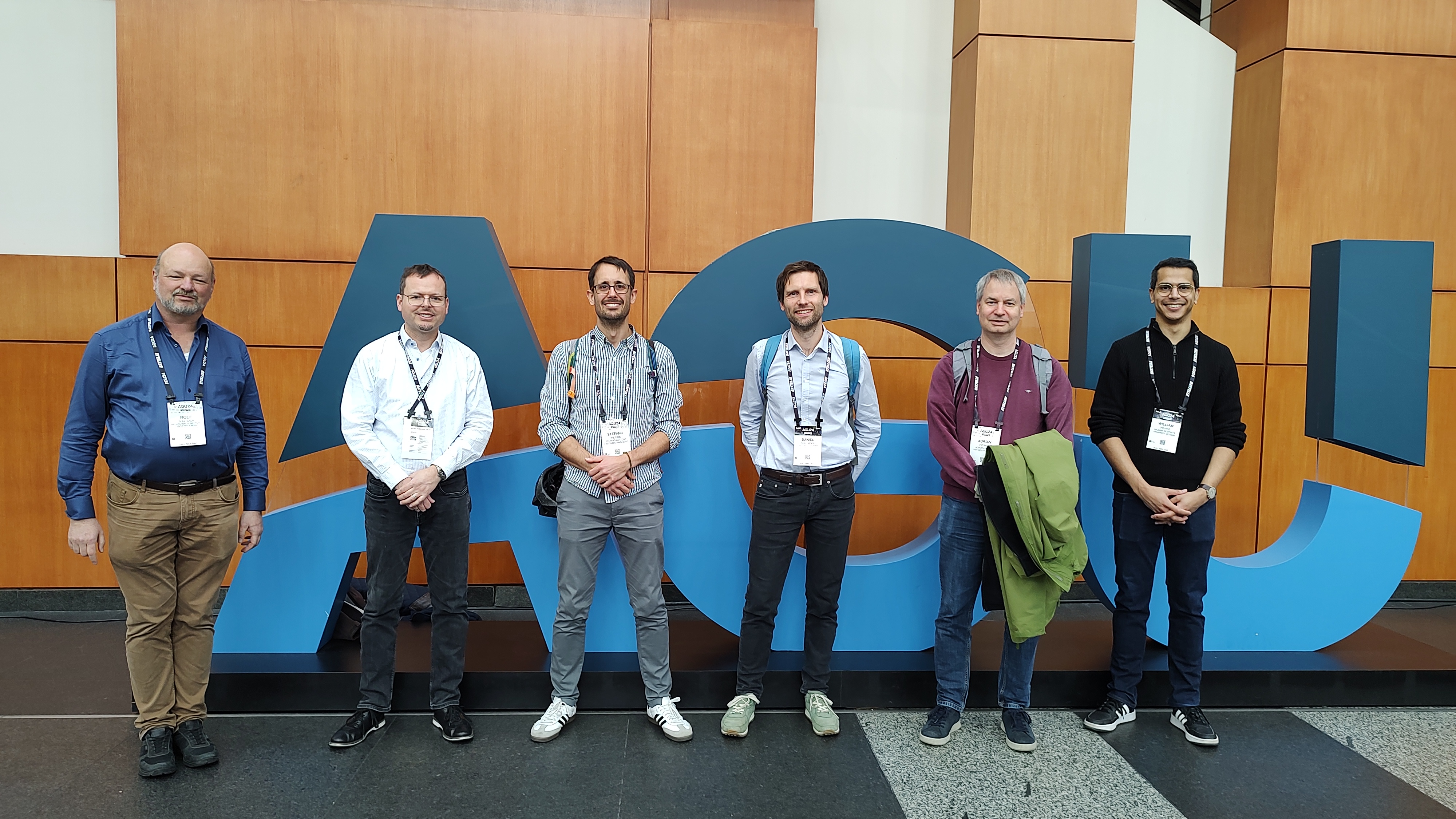 Members of the Astronomical Institute of Bern stand in front of the American Geophysical Union logo in Washington, December 2024
